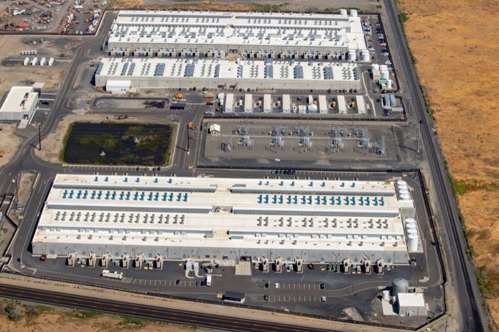 A modern hyperscaler data center — the physical layer that powers every workspace-native app, now mostly invisible to the people who build on top of it. Photo via Wikimedia Commons.